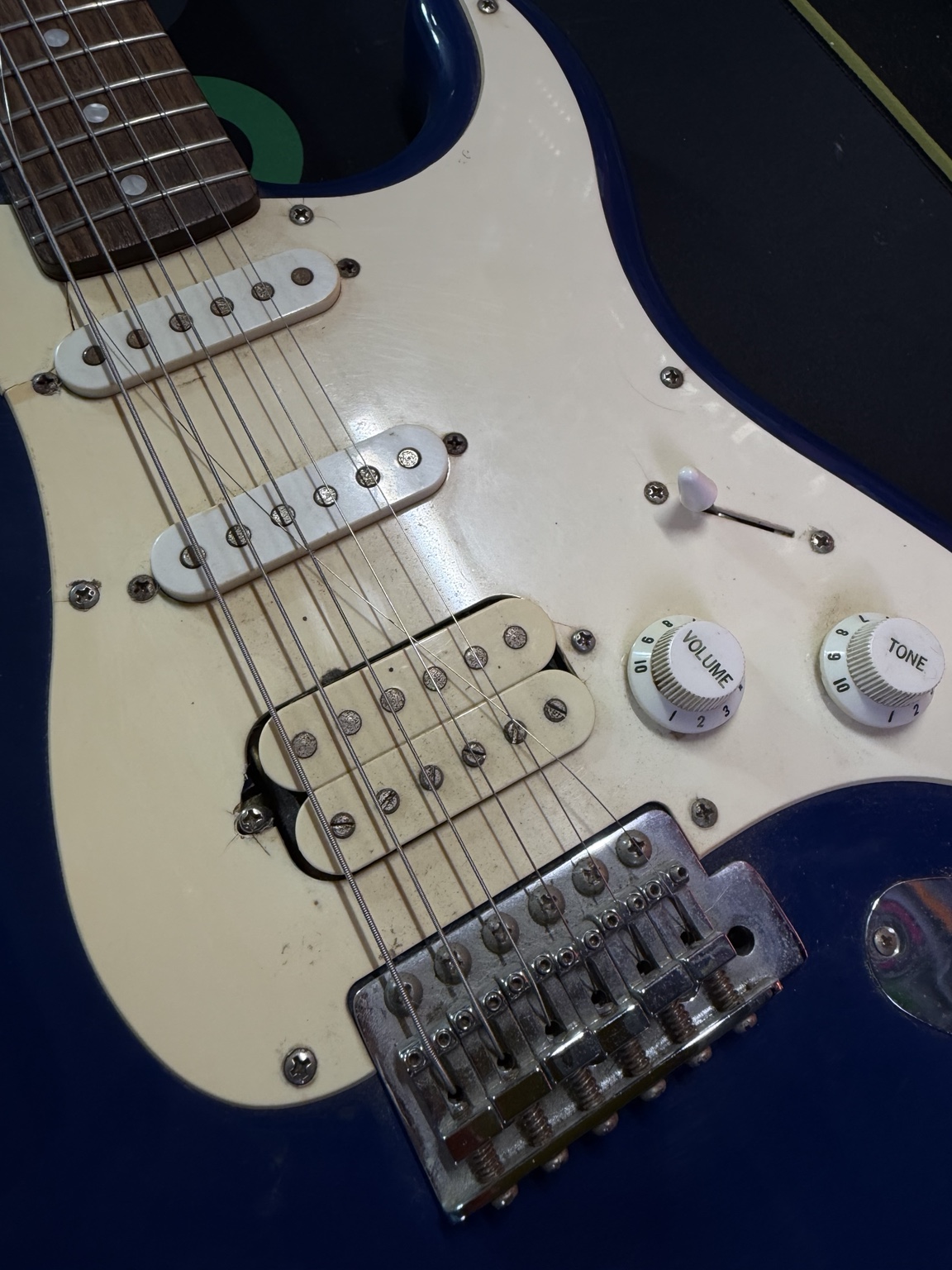 Before restoration: full view of blue Squier Stratocaster with aged cream pickguard and worn hardware